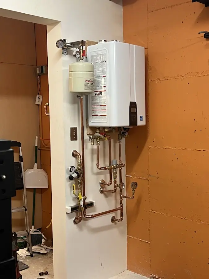 Plumbing technician inspecting water heater connections in Freeport
